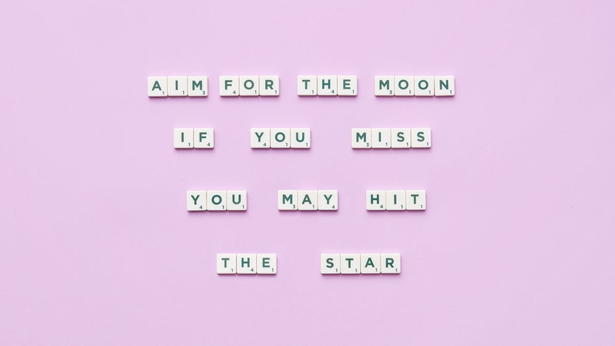 Inspirational message using Scrabble tiles on a pastel background.
